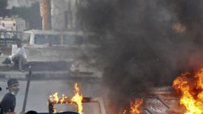 Manifestantes egipcios se reúnen alrededor de un vehículo en llamas en el centro de El Cairo, Egipto, antes que la policía despejara el área después de días de protestas en contra de una película que ridiculiza al profeta Mahoma.