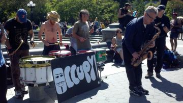 Un grupo dió ayer el toque musical a la precelebración del primer aniversario del movimiento "Occupy Wall Street" (OWS) que se cumple mañana. Abajo, otro grupo se prepara para iniciar la jornada de manifestaciones.
