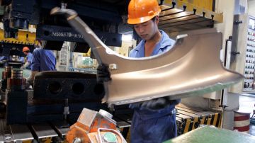 Un trabajador chequea las partes de un carro en un taller de mecánica en  Ningbo, China. La disputa ahora es por las exportaciones de automóviles.