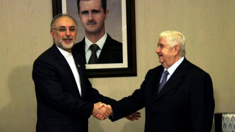 El ministro sirio de Exteriores, Walid al Moallem (dcha), estrecha la mano de su homólogo iraní, Ali Akbar Salehi, en Damasco (Siria).
