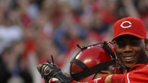 Dioner Navarro y Joey Votto se abrazan para celebrar el logro de los Rojos de Cincinnati frente a los Dogers.