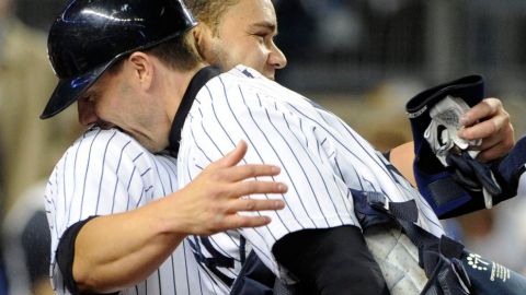 Russell Martin y Chris Stewart de los Yanquis se abrazan tras la victoria ante los Atléticos.
