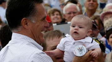 El candidato presidencial republicano y exgobernador de Massachusetts, Mitt Romney carga a un bebé que viste un 'Dump Obama'  durante  un acto, en Pueblo, Colorado, ayer.