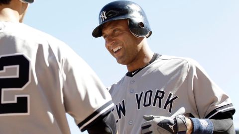 Derek Jeter es felicitado por Eric Chávez en el triunfo ante Minnesota que permite a los Yanquis seguir aventajando a los Orioles.