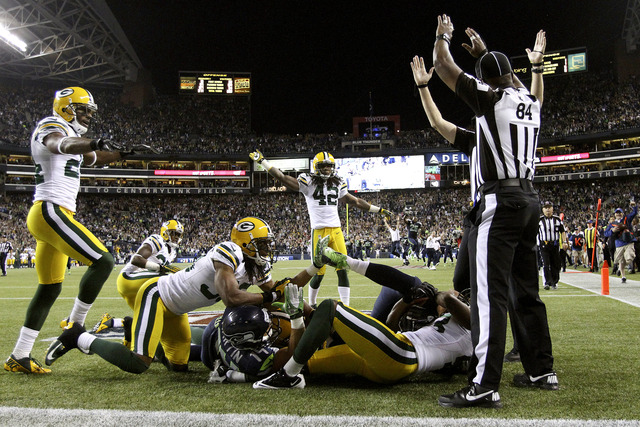 Los árbitros sustitutos (derecha) decretan un TD en el controversial desenlace del juego entre  Seahawks y Packers.
