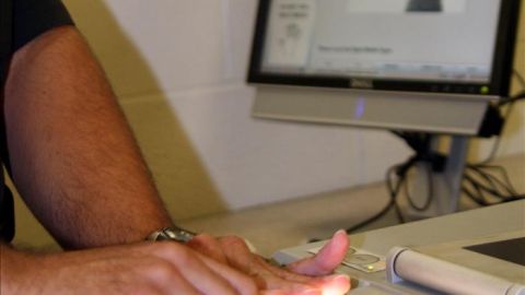 Un agente procesa a un detenido hispano sin identificar en el marco del programa migratorio Comunidades Seguras.