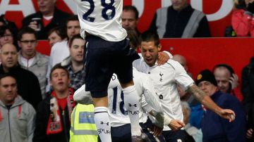 El delantero del Tottenham, Clint Dempsey (der.), es felicitado tras anotar su gol ante el Manchester United en el Old Trafford.