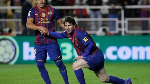 El chileno Alexis Sánchez (izq.) ayuda a levantarse a su compañero Lionel Messi (d).