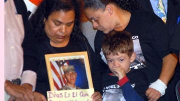 Sixta Piñeiro, abuela del joven asesinado Noel Polanco sostiene una foto de su nieto, mientras la madre, Cecilia Pérez, observa en llanto.