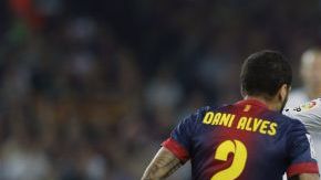 Danni Alves mientras se disputaba la bola ayer con Mesut Ozil, del Real Madrid.