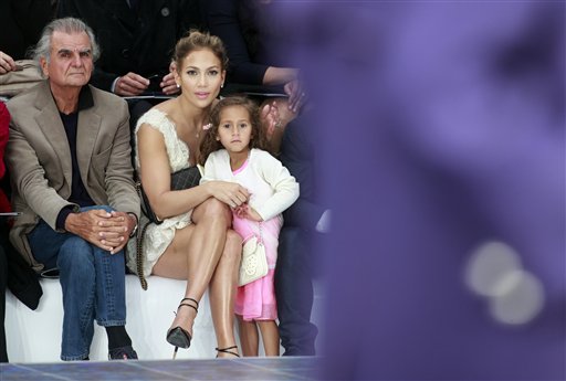 Emme disfrutando junto a su famosa madre Jennifer López del desfile de Chanel París. Nótese el bolso blanco que le prestaron.