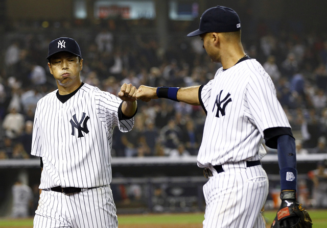 El capitán de los Yankees, Derek Jeter (der.), se saluda con  el lanzador nipón Hiroki Kuroda, quien abrirá esta noche ante Baltimore.