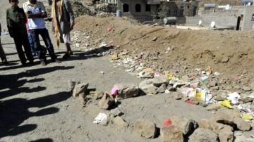 Yemeníes observan el lugar en el que fue asesinado un oficial yemení encargado de coordinar los servicios secretos yemeníes y la embajada estadounidense en Saná, Yemen.