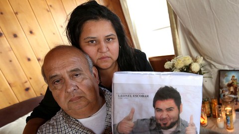Don Leonel Escobar, acompañado de su hija Ana Escobar, muestra la foto de su hijo  fallecido.