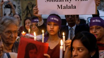 Paquistaníes sujetan carteles en apoyo a la joven activista por la paz de 14 años Malala Yusufzai, que fue tiroteada el pasado martes por los talibanes.