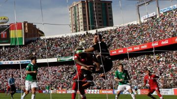 El peruano Christian Ramos pelea una pelota con el portero de la selección de  Bolivia, Hugo Suárez, en el choque disputado en La Paz.