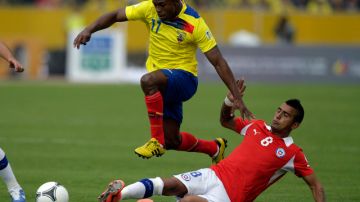El ecuatoriano Christian Benítez trata de superar la marca del rival chileno, Arturo Vidal durante el cotejo en Quito.