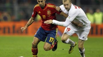 El jugador de España Álvaro Arbeloa (izquierda) busca quitarse la marca de  Maksim Bordachev de Bielorrusia que cayó goleada en las eliminatorias.