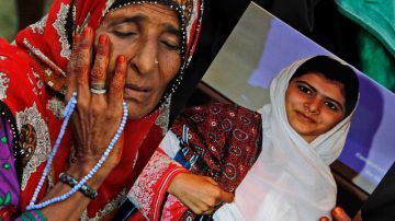 Un partidario del partido Muttahida Qaumi Movement (MQM), llora mientras sostiene un cartel con la foto de la niña, de 14 años de edad, Malala Yousufzai.