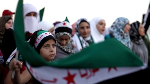 Jóvenes manifestantes protestan en Jordania frente a la embajada Siria.