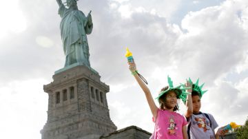 Unos niños posan frente a la Estatua de la Libertad.