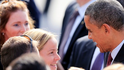 El presidente Barack Obama devuelve a August O'Brien, de dos meses, a las manos de su madre durante una visita de campaña en Manchester, New Hampshire. Un estudio revela que pese a su victoria la gente discrimina a los afroamericanos.