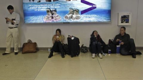 Temprano el domingo comenzaron a registrarse escenas como esta en el aeropuerto LaGuardia, de Nueva York, con pasajeros en las esquinas esperando que sus vuelos pudieran salir.