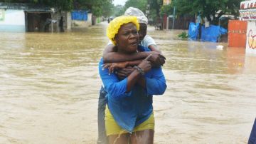 Dos mujeres caminan por una calle inundada  tras el paso del huracán Sandy  por  Puerto Príncipe, Haití.