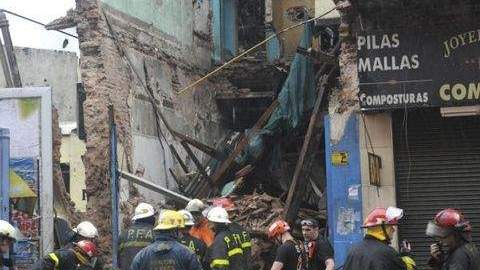 Bomberos remueven escombros de un local que se derrumbó esta mañana en un barrio de Buenos Aires, debido a las fuertes lluvias.