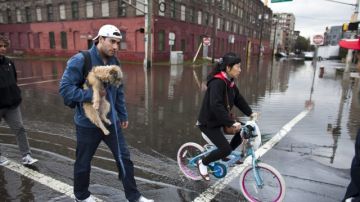 Residentes de Hoboken, Nueva Jersey caminan por las calles inundadas de su ciudad, tras el paso del huracán. Numerosas zonas de ese estado continuaban sin  transporte ni electricidad.