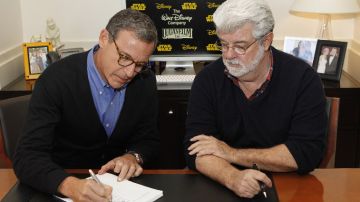 El presidente y CEO de Disney, Robert Iger (izquierda), y  George Lucas, de LucasFilm Ltd., mientras firmaban el contrato de compra.