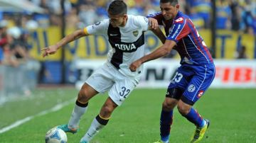 El juvenil Leandro Daniel Paredes (32), autor de dos goles para   Boca Jr., intenta el desborde sobre  Ezequiel Mastrolía de San Lorenzo.