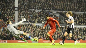Luis Suárez (centro),  supera a Tim Krul,  portero del Newcastle, para anotar el gol del empate para Liverpool,   ayer en Anfield Road.