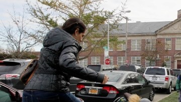 Una mujer y su hijo pasan por encima de un árbol para llegar hasta la escuela pública 195, en Manhattan Beach, Brooklyn, ayer.