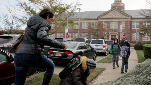 Una mujer y su hijo pasan por encima de un árbol para llegar hasta la escuela pública 195, en Manhattan Beach, Brooklyn, ayer.