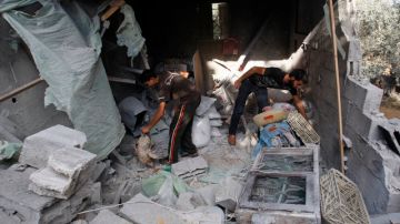 Palestinos buscan sus pertenencias en una casa destruida  por un ataque aéreo israelí ayer en Beit Lahiya, al norte de la Franja de Gaza. En las últimas horas, Israel ha efectuado varios  bombardeos en el sur de la ciudad.