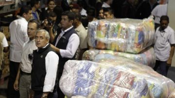 Otto Pérez Molina aparece revisando los paquetes de ayuda para los damnificados  en la sede Nacional para la Reducción de Desastres (Conred).