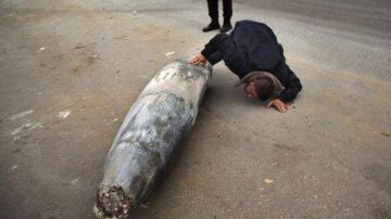 Un oficial de Hamas inspecciona una bomba israelí que no explotó, luego de ser lanzada hacia Gaza.