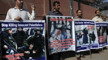 Manifestantes paquistaníes sujetan pancarta contra la ocupación israelí durante una protesta contra los ataque del ejército israelí en Gaza.