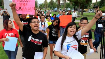 Joshua Montano (i) y Deborah Robles protestan frente al Capitolio de Phoenix, un día después de que la gobernadora de Arizona, Jan Brewer, diera la orden de negar permisos de conducir a beneficiarios de la acción diferida.