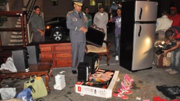 Miembros de la policía inspeccionan los objetos sustraídos de la casa donde asesinaron a unos ancianos y el robo fue planeado por una trabajadora.