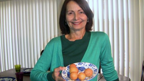 Niza Rodríguez muestra un plato de buñuelos dorados y esponjosos en su casa en Los Ángeles, California.