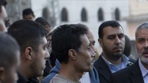 El primer ministro de Hamás en Gaza, Ismail Haniyeh (c), habla con los vecinos de una zona dañada durante los choques en la Ciudad de Gaza.