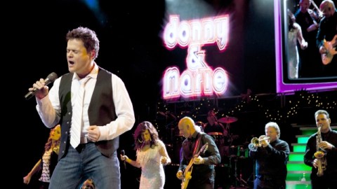 Donny (primer plano, izq.) y Marie Osmond (detrás, de blanco) en un instante de su show, que llega al Pantages Theatre de la ciudad el próximo día cuatro.