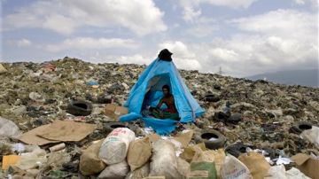 Jonathan Nunez, un recogedor de basura, está sentado dentro de una tienda rodeado de bolsas que contienen basura reciclada que recolectó durante el día en un vertedero de basura en Rafey al norte Santo Domingo, República Dominicana.