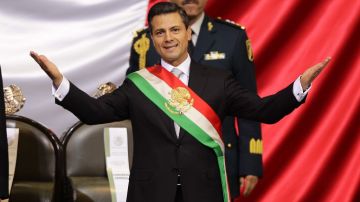 El mandatario de México, Enrique Peña Nieto, se ciñe la banda presidencial durante su investidura.