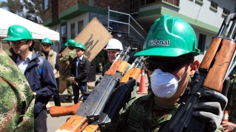 Soldados y trabajadores de una una empresa fundidora transportan 41,000 armas para su destrucción luego de ser decomisadas a la guerrilla.