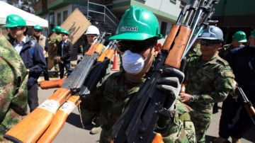 Soldados y trabajadores de una una empresa fundidora transportan 41,000 armas para su destrucción luego de ser decomisadas a la guerrilla.