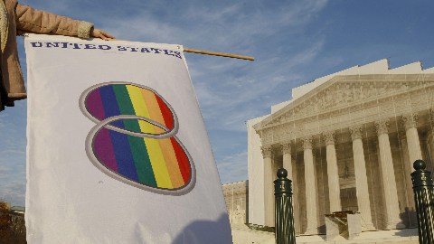 Una manifestante que favorece los matrimonios entre personas del mismo sexo levante una bandera gay frente a la Corte Suprema.