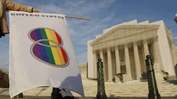 Una manifestante que favorece los matrimonios entre personas del mismo sexo levante una bandera gay frente a la Corte Suprema.